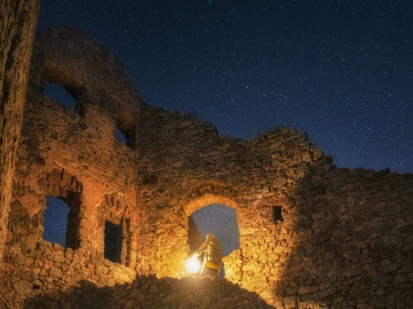Detailný záber na zrúcaninu hradu Hrušov a hviezd na oblohe.
