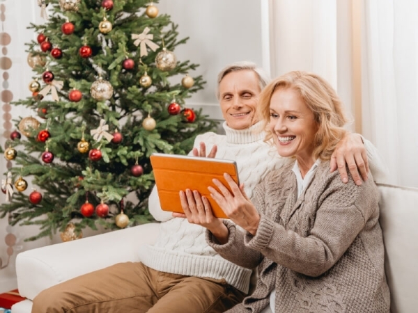 Manželský pár telefonuje cez videohovor na tablete počas vianočných sviatkov.